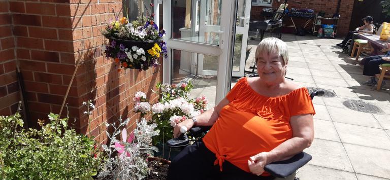 Picture of Judith, a resident at Greenside Court, sat outside in the garden