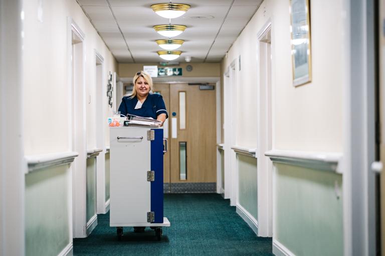 Picture of female nurse in care home with medication trolley
