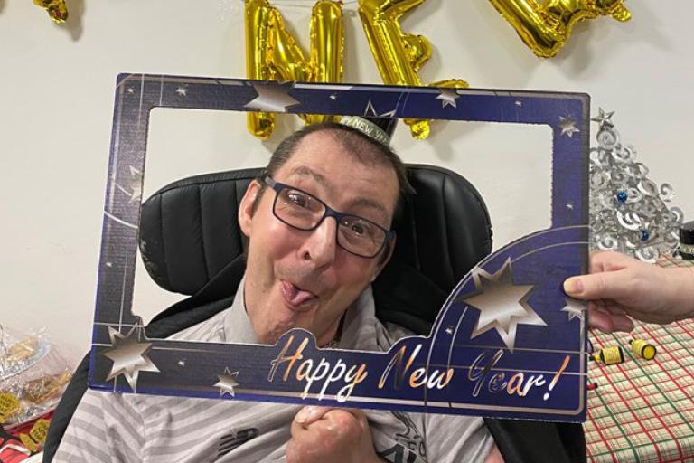 Male resident with 'Happy New Year' sign