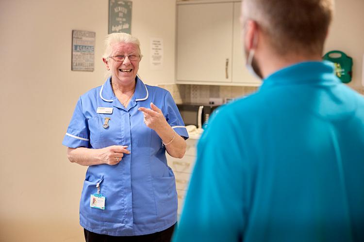 Nurse in blue uniform smiling at camera