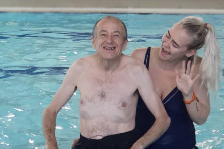 Male service user in pool with carer