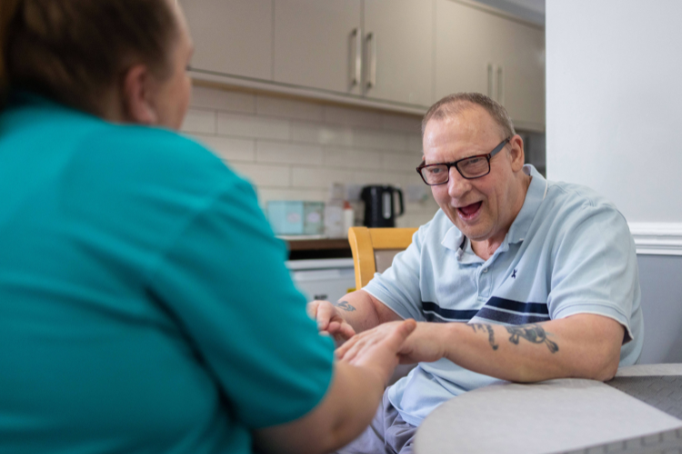 Smiling man looking at Health Care Assistant