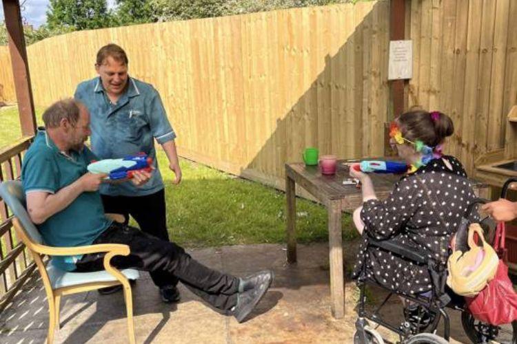 Service users having a water fight with Health Care Assistants