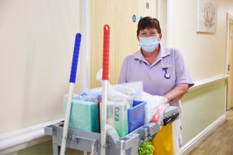 Domestic Assistant with a trolley full of supplies