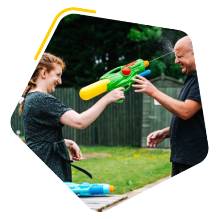 Female service user playing with a water pistol with care worker