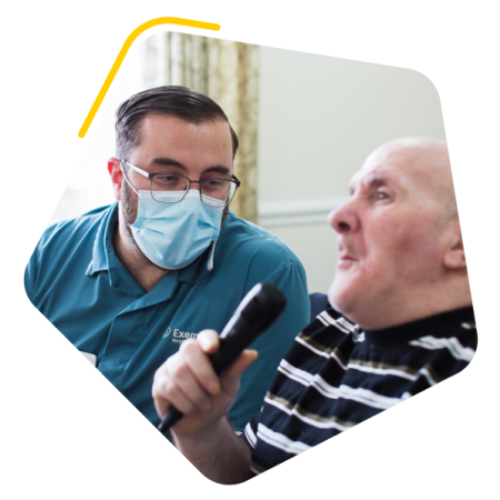 Care worker and care home resident singing karaoke